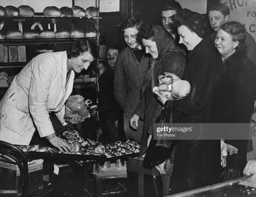 Old Kent Road, c1947. Brisk business at the bakers for hot cross buns.   X.png