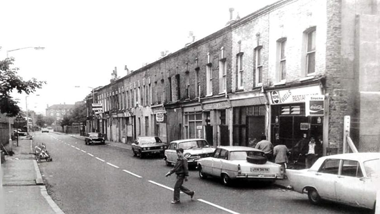 Wells Way, c1979. The Wells restaurant and buildings at 68-106 Wells Way, looking south towards Parkhouse Street.   X..png