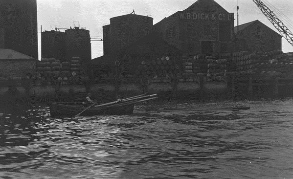 Surrey Docks,1930. Watermen salvaging floating deals from the Thames near Condemned Hole Wharf, Lavender Dock left.  X..png