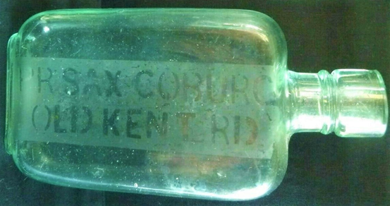 Old Kent Road, on the corner with Chesterfield Way. an off-licence spirit bottle with the name of the Prince of Saxe Coburg Public House. (c1890).   X..png