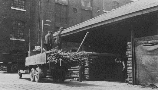 Surrey Commercial Docks, Bundles of rattan being loaded onto the back of an open lorry, c1930.  X..png