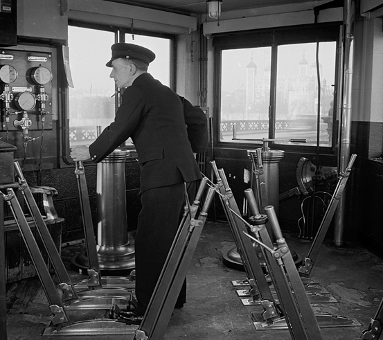 Tower Bridge driver works the controls during the raising of the road inside the control cabin in 1951.    X..png