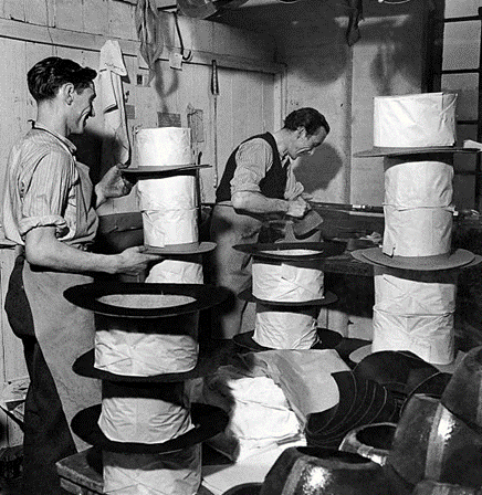 Harry Parbott and Reg Marriott, two top hat craftsmen, pressing hats they have made in Bermondsey, 1948..png