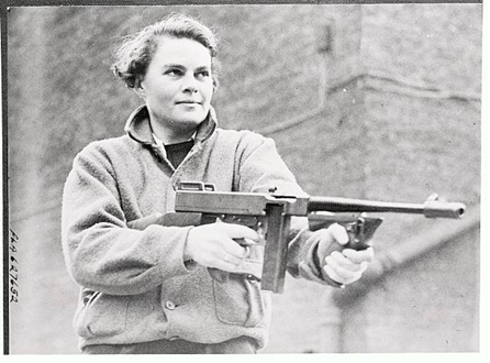 Miss E. Blakeley, a clerk, practices with a Tommy-gun during a drill of the women municipal workers of Bermondsey, WW2.  X..png