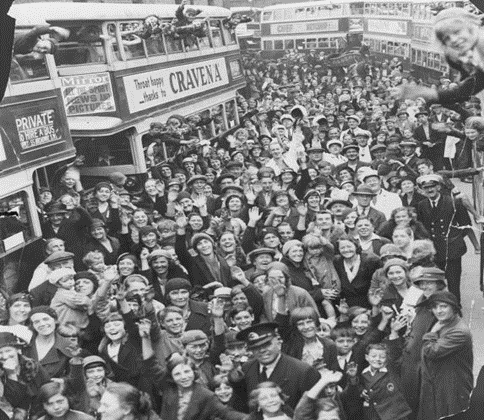 Neptune Street, Rotherhithe, 1934. Twenty-five buses are taking the children for a day out at Gray's Retreat, Theydon Bois, Essex, Transport Workers' Children's Outing.   X..png