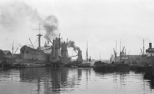 Surrey Docks, Canada Dock with the Dulwich discharging grain at the floating grain elevators and the basin full of timber barges, c1931.   X..jpg