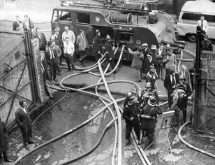 Stamford Street, firefighters, and onlookers at the Broadwall entrance of Lyons Maid, c1968.  X..png