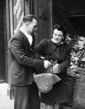 WW2, Private Ted Saunders of the 2nd Army out shopping with his wife Margaret in Bermondsey while on leave,1945.   X..png