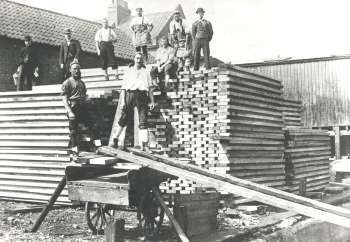 Deal Porters, Surrey Commercial Docks, Rotherhithe, 1910. Moving lengths of timber from ship, warehouse, lorry and barge.  X.jpg