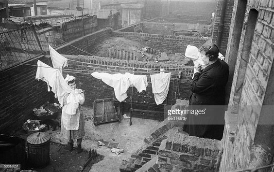 A woman and baby look on as a Southwark housewife hangs out her washing in the Elephant and Castle area of south London, 8th January 1949.   X.jpg