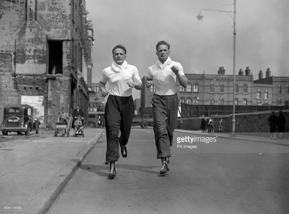 Albany Road, British boxer Henry Cooper - left) and his twin brother George during a training session at the Thomas a Becket gym on the Old Kent Road (background).jpg