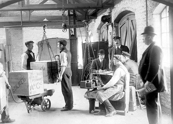 DOCK WORKERS CHECKING THE WEIGHT OF BOXES C1910..jpg