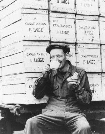 London Surrey Commercial Docks worker drinking tea, surrounded by crates of eggs from Canada about a year after the end of WWII 1946 .   X.jpg