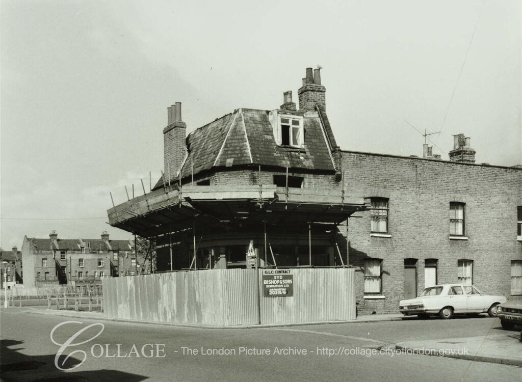 Loncroft Road, No.66a, during demolition. Scaffolding covers much of the house. A sign states GLC Contract Syd Bishops & Sons Demolition Ltd.  c1977.  X.png