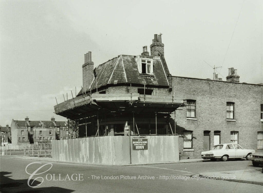 Loncroft Road, No.66a, during demolition. Scaffolding covers much of the house. A sign states GLC Contract Syd Bishops & Sons Demolition Ltd. c1977. X.png