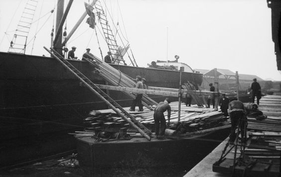 Discharging deals, battens and boards from the SS 'Portos' at Russia Dock, Rotherhithe. Deal was a softwood timber that was imported to the Surrey Docks.   X.png