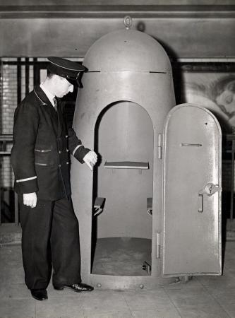 WW2. Small two-person air-raid shelter, a member of uniformed staff looks on, c1935.  X.png