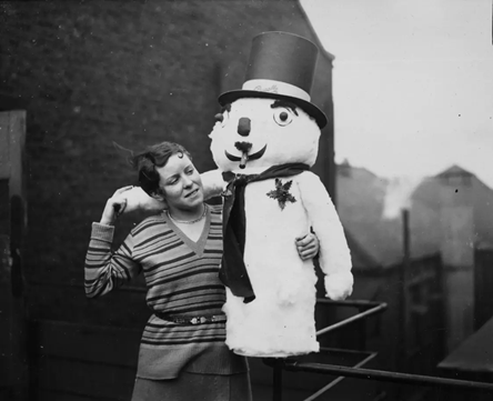 Blackfriars Road 1930.A young girl with a toy-filled snowman at Messrs Pascalls in Blackfriars, London.   X.png