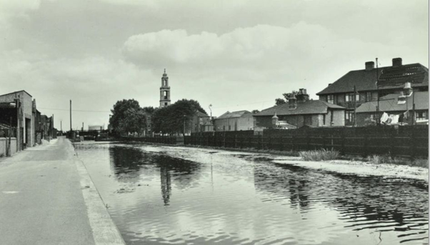 Surrey Canal c1956, when it was still water-filled, west of the Wells Way bridge (in the distance with St Georges Church to its right).  X.png